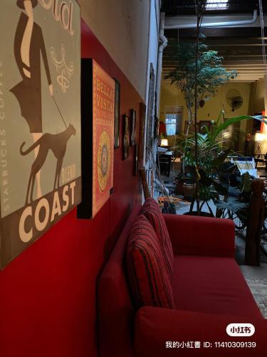 a red couch against a wall in a restaurant at Bitterswiit Ladies Hostel in George Town