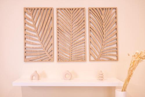 a room with three wooden screens on the wall at Le Balinais - Avec Sauna et Balnéo in Dunkerque