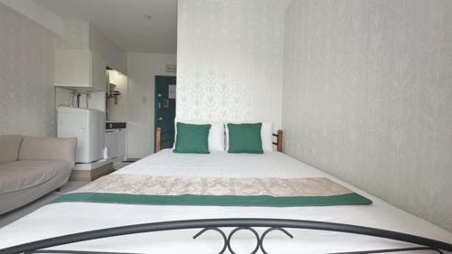 a bedroom with a large bed with green pillows at Ikebukuro 706 in Tokyo