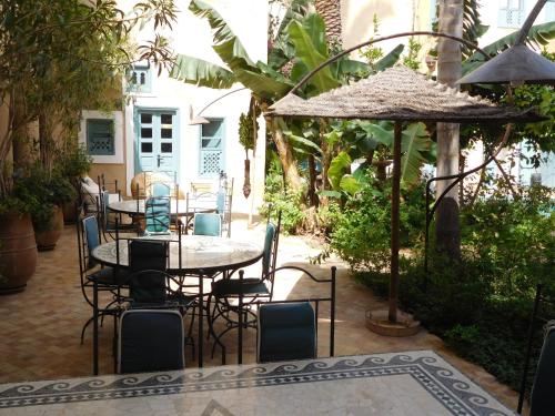 a patio with a table and chairs and an umbrella at Palais Oumensour in Taroudant