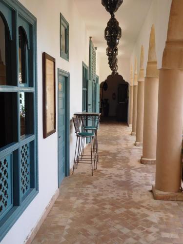 a corridor of a house with a hallway with blue doors at Palais Oumensour in Taroudant