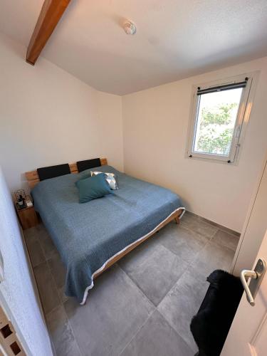 une chambre avec un lit avec une couverture bleue dans l'établissement Maison Lagune bleu, à Gruissan