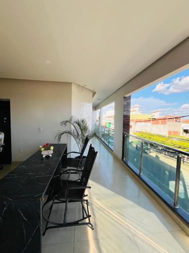 a dining room with a table and chairs and a large window at Apartamento panorâmico com 2 suítes 1 quarto in Petrolina
