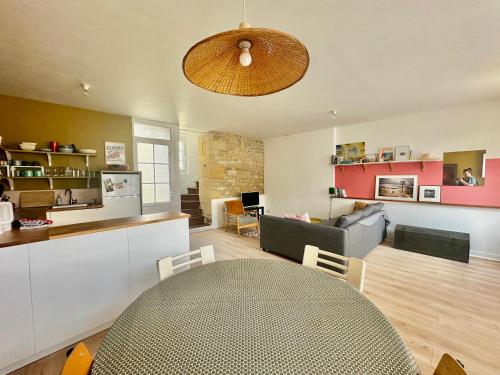 un salon avec une table et un canapé dans l'établissement La courette, maison avec cour proche plage, à Graye-sur-Mer