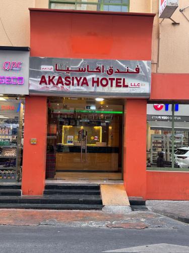 a store front of a akiasma hotel with a red facade at Akasiya Hotel - Formerly known as Fal Hotel in Dubai