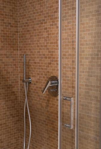a shower with a shower head in a brick wall at Downtown loft in Naples in Naples