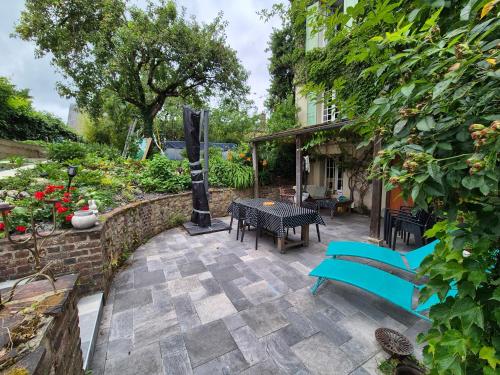 a patio with a table and chairs and a building at Maison proche de la gare in Lisieux