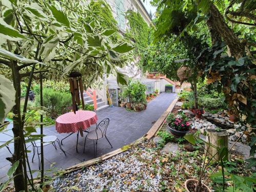 a patio with a table and chairs in a garden at Maison proche de la gare in Lisieux