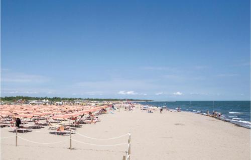 a beach with a lot of people and umbrellas at La Piazzetta in Rosolina Mare