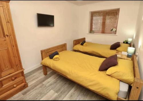 a bedroom with two beds with yellow sheets at The Pepper pot in Niton
