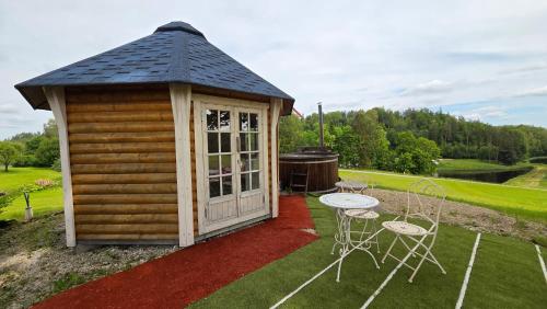 a small cabin with a table and chairs at Järvevaatega Puhkemajake in Nüpli