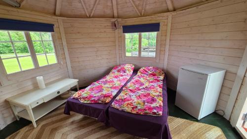 a small room with a bed and a refrigerator at Järvevaatega Puhkemajake in Nüpli
