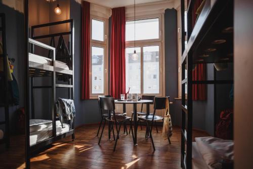a dining room with a table and chairs and a window at The Circus Hostel in Berlin