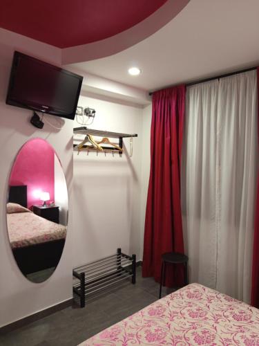 a bedroom with a mirror and a bed and a tv at B&B Lido Esperando in Sciacca