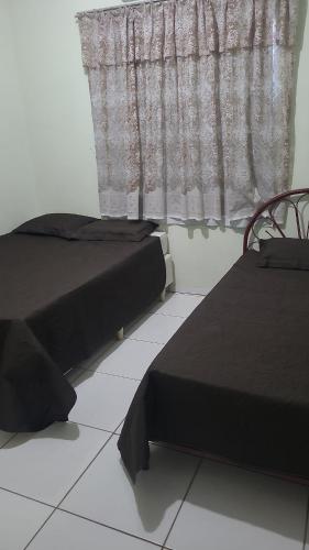 two beds in a room with a window at Terraço do Sol apt 02 in Marcelino Ramos