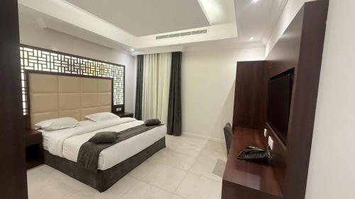 a bedroom with a large bed and a television at East Diamond Serviced Apartments in Jeddah