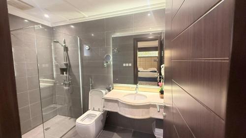 a bathroom with a toilet and a sink and a shower at East Diamond Serviced Apartments in Jeddah