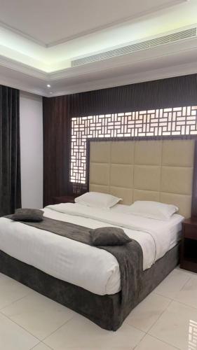 a bedroom with a large bed with a large window at East Diamond Serviced Apartments in Jeddah