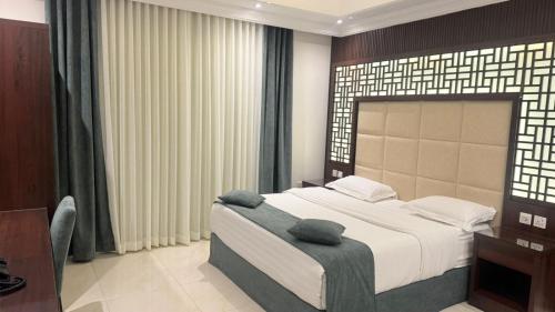 a bedroom with a large bed and a desk at East Diamond Serviced Apartments in Jeddah