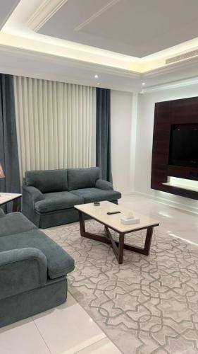 a living room with two couches and a coffee table at East Diamond Serviced Apartments in Jeddah