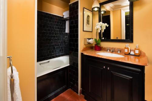 un baño con lavabo y bañera en Hotel Résidence Des Arts - Saint-Germain, en París