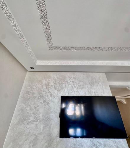 a ceiling with a tv on a marble floor at Wifak beach rental in Temara