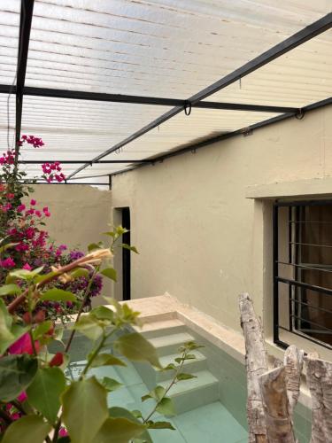 awning over a porch of a house with pink flowers at Simple Moroccan Rural Getaway in Tama ou Ennza