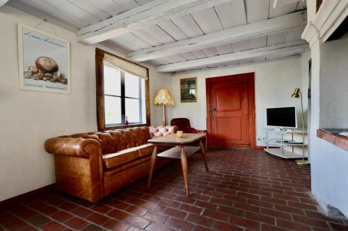a living room with a leather couch and a table at Gåvetorps Gård in Alvesta