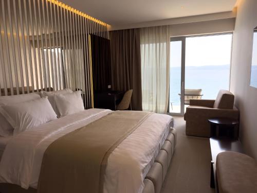 a hotel room with a large bed and a large window at Luxury Hotel Amabilis in Selce