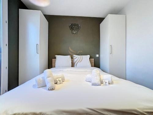 - une chambre avec un grand lit blanc et des oreillers blancs dans l'établissement T2 Éclat Carmin, A/C, terrace, pool, tennis, à Fréjus