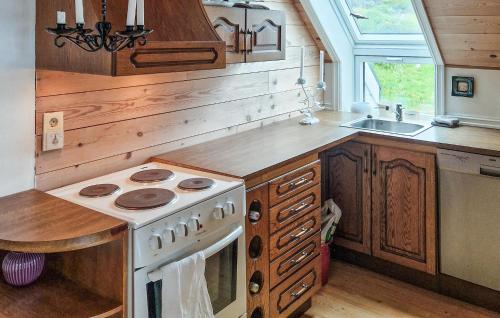 a kitchen with a stove and a sink at Nice Home In Manger With House Sea View in Manger