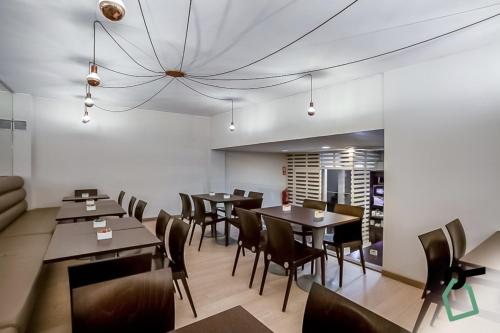 een restaurant met tafels en stoelen en een kroonluchter bij HOTIDAY Room Collection - Oporto in Porto