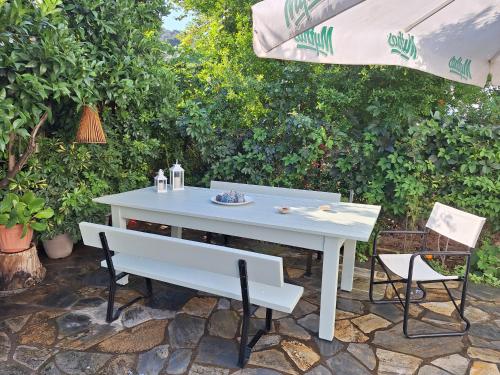 a white table and two chairs and an umbrella at Armonia & Anemos Family Apartments in Kálamos