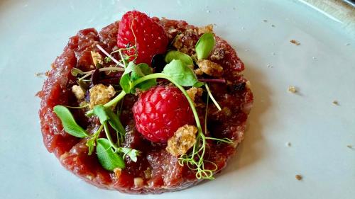 a plate of food with a raspberryastery on it at Agritur Anselmi in Terzolas