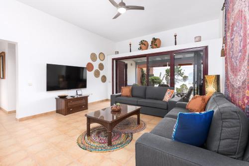 a living room with a couch and a table at Home2Book Casa Kiky - Cosy Villa with Jacuzzi in La Oliva
