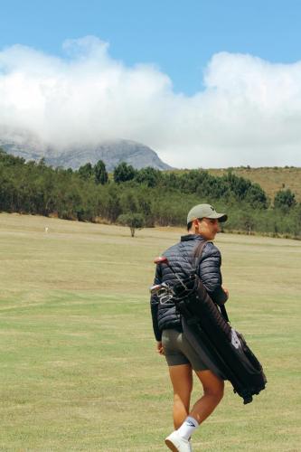 a man walking in a field with a baseball glove at Assegaaibosch Country Lodge in Kareedouw
