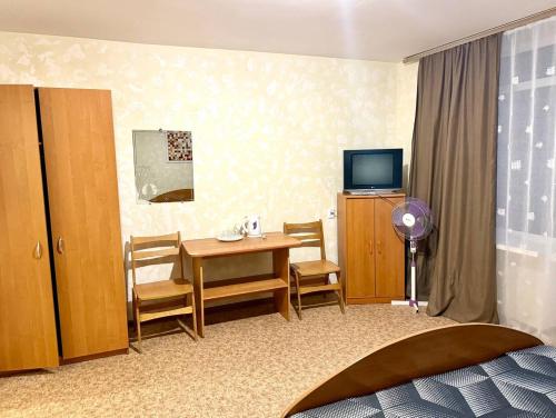 a hotel room with a table and a television at Ассоль in Koblevo