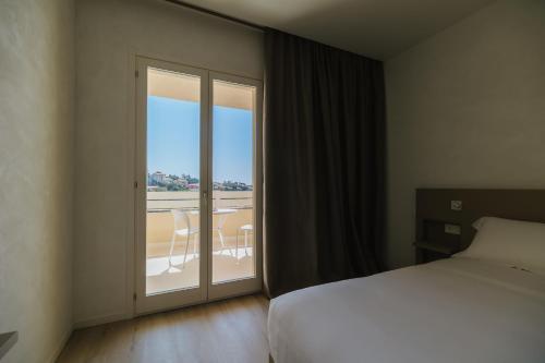 a hotel room with a bed and a sliding glass door at Maison Sirolo in Sirolo