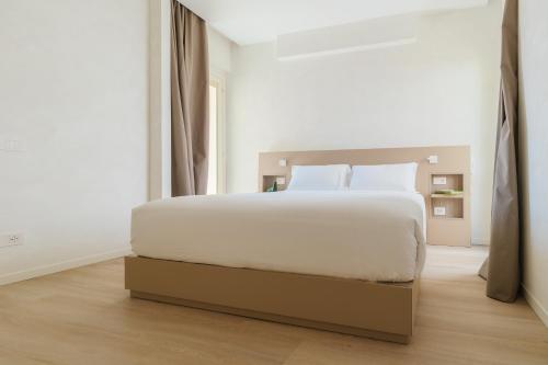 a white bedroom with a large bed in it at Maison Sirolo in Sirolo