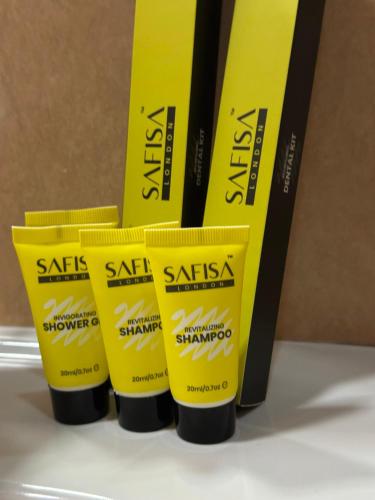 a group of four bottles of sunscreen sitting on a shelf at Hotel Gloria Standard in Borovoye
