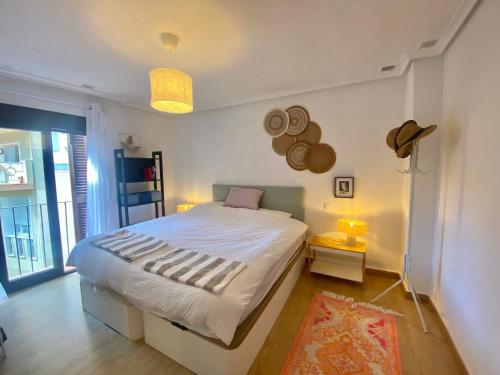 une chambre avec un grand lit blanc avec des chapeaux au mur dans l'établissement Casa De La Luz, à Carthagène