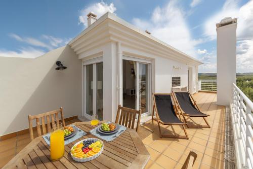 a patio with a table and chairs on a balcony at Baleal Oceanviews in Ferrel