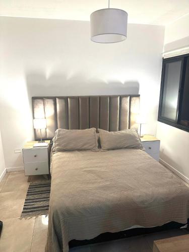 a bedroom with a large bed with a silver headboard at Temporario in Yerba Buena