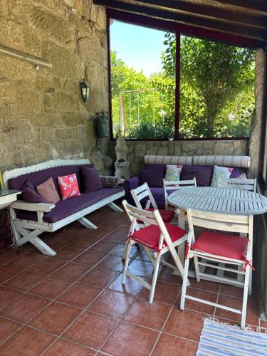 a patio with a table and chairs and a couch at Casa Matreiro in Proselo
