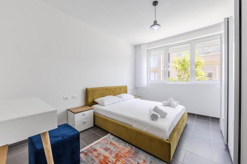a bedroom with a bed and a desk and a window at Talea Holiday Apartments 2 in Lezhë