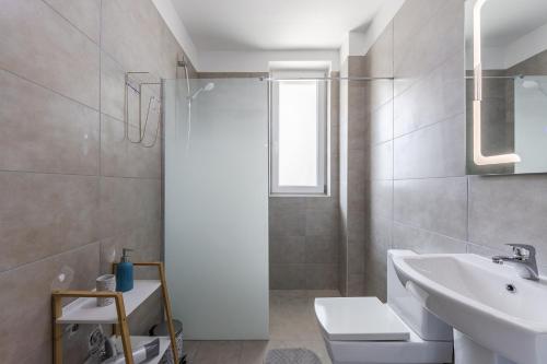 a white bathroom with a shower and a sink at Talea Holiday Apartments 2 in Lezhë