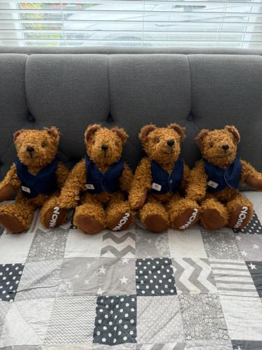 a group of four teddy bears sitting on a bed at Portstewart - holiday let in Portstewart