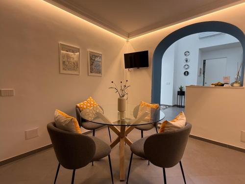 a dining room with a glass table and chairs at Casa Flavia Apartment in Anacapri