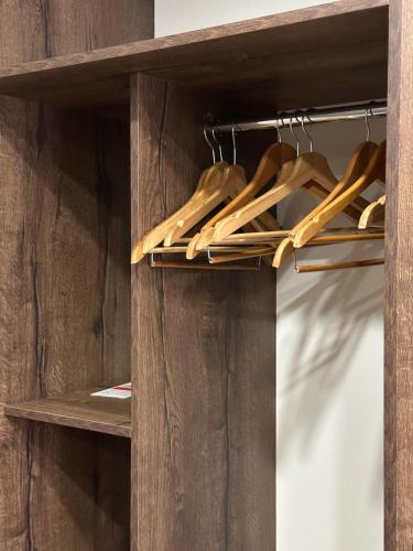 a wooden closet with wooden hangers and wooden shoes at Hotel Gloria Standard in Borovoye