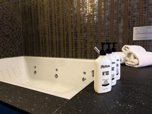 a bath tub with two bottles of lotion on a counter at Hotel Indigo Madrid - Gran Vía by IHG in Madrid